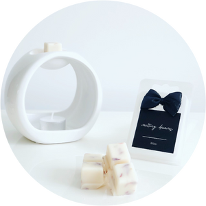 Luxury home fragrance. Highly fragranced wax melts with dried botanicals. Black label. White oval wax melt burner with tea-light.