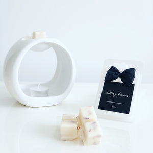 Luxury botanical bliss wax melts with a black label and white wax burner. 