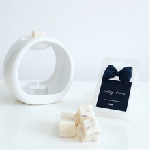 Load image into Gallery viewer, Luxury botanical relax wax melts with a black label and white wax burner. 
