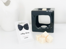 Load image into Gallery viewer, Luxury seychelles wax melts with a white label and black wax burner. 
