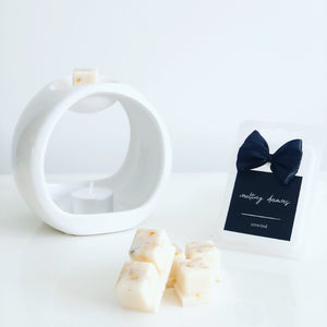 Luxury botanical unwind wax melts with a black label and white wax burner. 